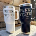 2 insulated travel mugs with handles in white and navy engraved with Penn State Lax logo